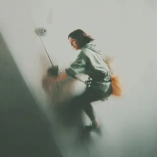 Teenage girl in a coaching session climbing an indoor wall